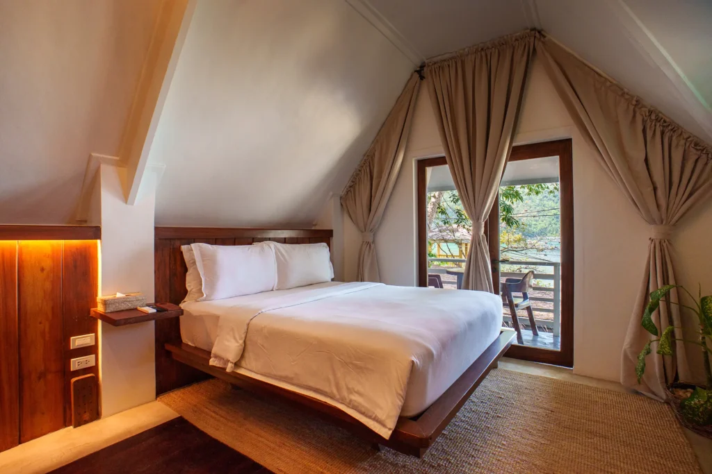 Queen bed and private balcony in Room Three at Morgan Villas, El Nido