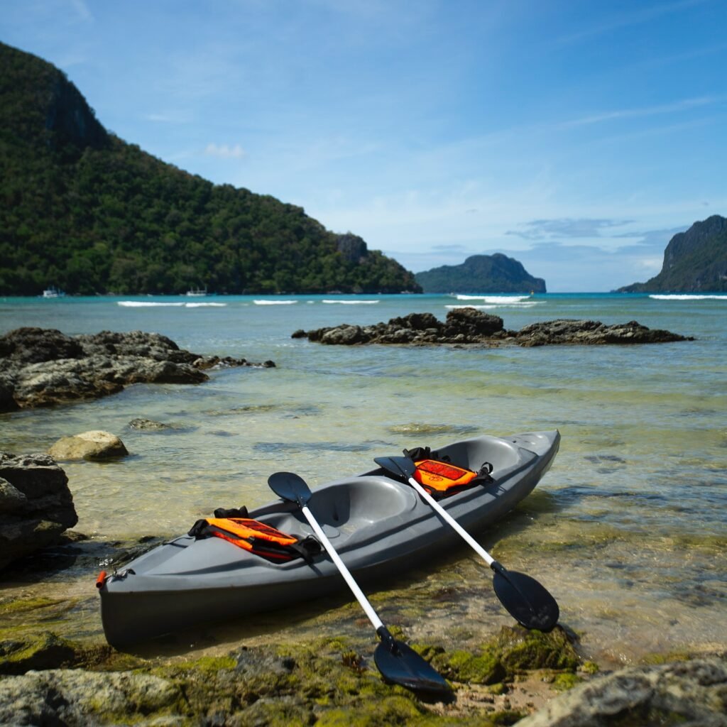 Tandem kayak with paddles and life jackets by the shoreline at Morgan Villas
