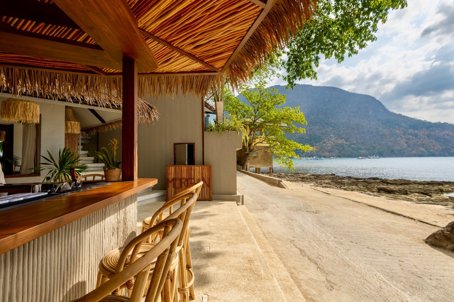 Open-air beach bar with a view across Bacuit Bay at Morgan Villas